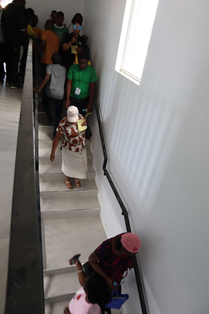 Group of people walking down a staircase in a bright, well-lit hallway.